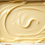 Cucchiaio che distribuisce la besciamella sul fondo