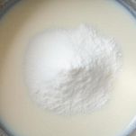 Ciotola con latte mentre lo zucchero si scioglie mescolando