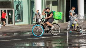 Corriere in bicicletta che consegna cibo al cliente