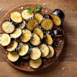 Mani che tagliano melanzane a fette spesse