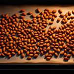 Mandorle disposte su una teglia mentre tostano in forno