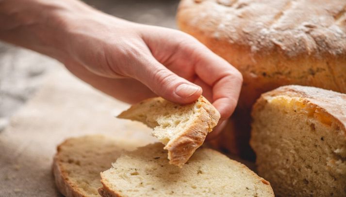 Donna che spezza il pane croccante