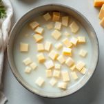 Ciotola con cubetti di formaggio coperti di latte