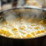 Pentola con crema di formaggio mescolata con cucchiaio