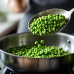 Contenuto della padella con piselli cotti versato nel frullatore da cucina