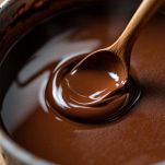 Cioccolato fondente sciolto nel latte caldo in un pentolino.