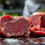 Tagli di carne cruda disposti sul tagliere.