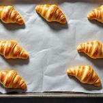 Cornetti crudi disposti su teglia.