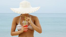 Donna al mare che beve una bibita