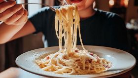 Donna mangia gustosa carbonara