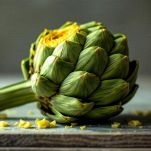 Mani che rimuovono le foglie esterne di un carciofo fino a raggiungere quelle più tenere