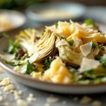 Piatto di carciofi crudi con scaglie di Parmigiano pronto per essere servito