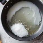 Pentolino sul fuoco con acqua e zucchero che si sciolgono lentamente