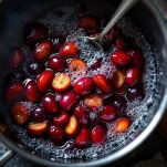 Casseruola con marmellata di susine in cottura mentre viene mescolata