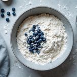 Ingredienti secchi con mirtilli mescolati in ciotola.