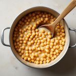 Pentola con ceci cotti mentre una parte viene frullata per creare una crema