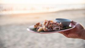 Piatto di calamari alla griglia con il mare sullo sfondo