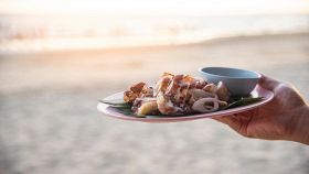 Piatto di calamari alla griglia con il mare sullo sfondo