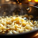 Padella con trito di cipolla e aglio che imbiondisce nel burro e olio