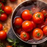 Bicchiere del robot con pomodori a pezzi e spicchio d’aglio