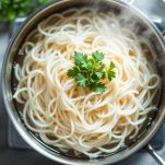 Pentola con spaghetti di riso in cottura