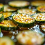 Padella con zucchine in pastella immerse nell’olio bollente