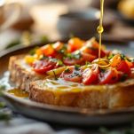 Cipolla e origano distribuiti sul pane condito.