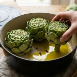 Carciofi pronti per la cottura con acqua e olio sul fondo