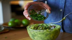 Donna aggiunge peperoncini al guacamole