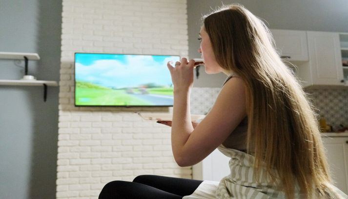 Donna mangia mentre guarda tv