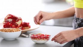 Donna prepara colazione sana con yogurt e granola