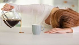 Donna stanca versa il caffe sul tavolo