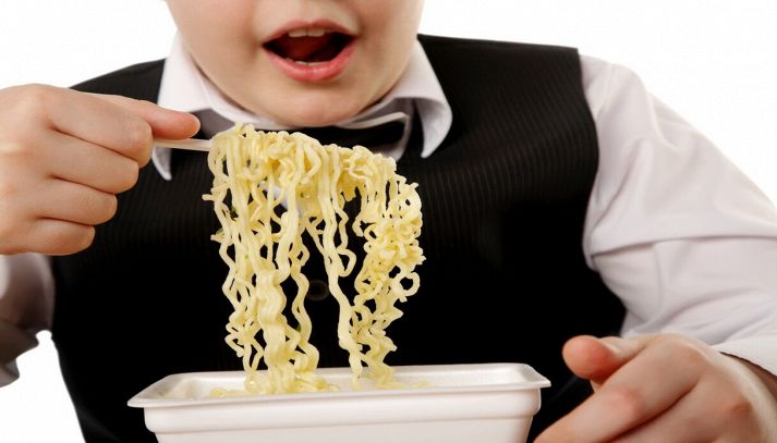 Ragazzo mangia pasta istantanea