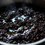 Riso venere che cuoce in pentola con acqua bollente