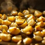 Pentola con brodo vegetale e padella con aglio che soffrigge