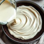 Crema versata sulla base con biscotti sbriciolati