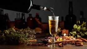 Versare liquore alle erbe nel bicchiere