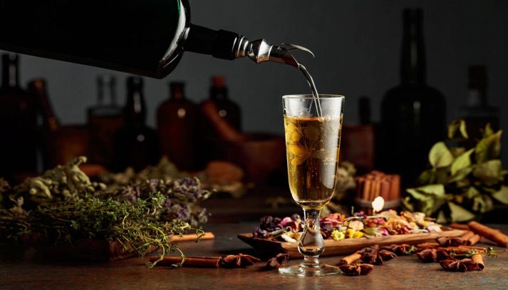Versare liquore alle erbe nel bicchiere
