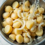 Ciotola con patate e cipolle grattugiate pronte per l’impasto