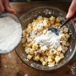 Ciotola con patate grattugiate, uovo e farina mescolati