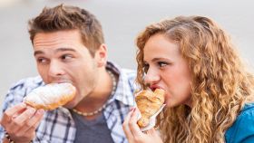 Coppia fa colazione col cornetto al bar