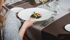 Donna mangia mezza porzione di pasta al ristorante