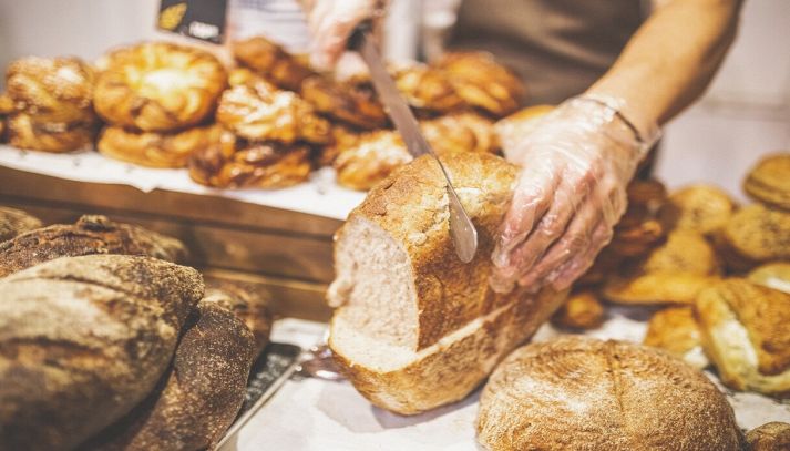 Panettiere taglia un fragrante pane integrale