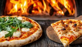 Pizza con spinaci e formaggio su un tagliere di legno