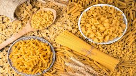 Tanti tipi di pasta con spighe di grano sulla tavola