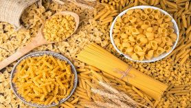 Tanti tipi di pasta con spighe di grano sulla tavola