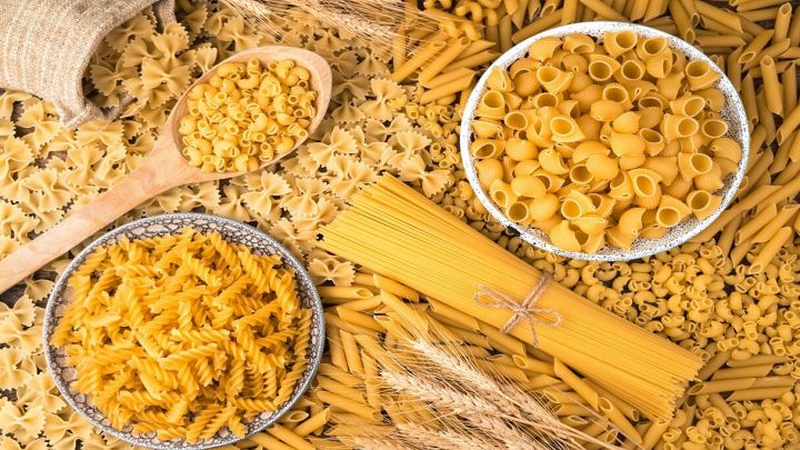 Tanti tipi di pasta con spighe di grano sulla tavola
