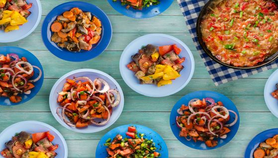 Pesce e verdure servite su piatti colorati