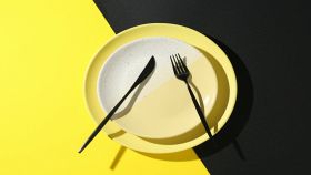 Piatti eleganti con posate su sfondo colorato