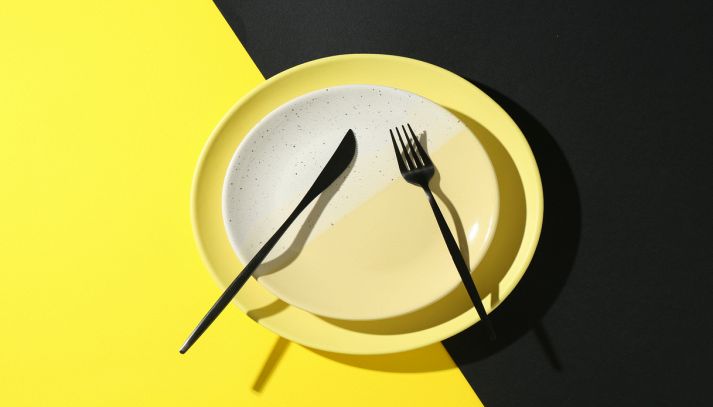 Piatti eleganti con posate su sfondo colorato